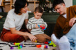 © Nuria Seguí/Stocksy - Parents are occupied with their child's play