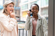 © Iryna - Friends enjoy a moment together while one talks on a phone in the city street