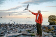 © Anna Artemenko/Stocksy - An elderly man feeds seagulls by the sea