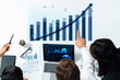 © InfiniteFlow - Team members collaborate during a strategic meeting, analyzing performance data, graphs, and insights displayed on screens and documents for business growth. Axiom