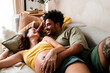 © Ibai Acevedo/Stocksy - Cheerful pregnant couple having fun on sofa