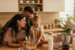 © La Famiglia - Family cooking together in modern kitchen laughing