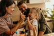 © La Famiglia - Parents and daughter celebrating with birthday cake tasting