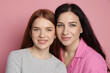 © New Africa - Portrait of mother and her smiling teenage daughter on pink background