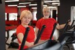 © New Africa - Senior couple training on elliptical machines in gym
