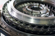 © Jumain - Close up high angle of a shiny metallic turbine engine component with intricate mechanical details and precision engineering parts in a workshop.