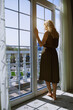 © ADDICTIVE STOCK - Woman standing by a balcony window under sunlight