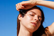 © Artem Podrez/Stocksy - Woman skincare summer serum drop on glowing skin outdoors