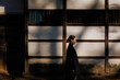 © JIE MA/Stocksy - Elegant Woman Strolling in an Old Alley Amidst Light and Shadow.