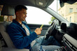 © Boris Jovanovic/Stocksy - Good-looking man is on his phone in a car.