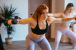 © Manu Padilla/Stocksy - Women training with dumbbells during fitness class