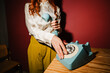 © Nuria Seguí/Stocksy - Woman dials a vintage telephone