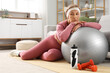 © Pixel-Shot - Sporty mature woman with fitball experiencing menopause at home