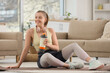 © Pixel-Shot - Sporty young woman with protein shake sitting on yoga mat at home