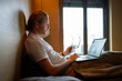 © Artcore Studio/Stocksy - Man using laptop while sitting on bed in cozy room