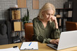 © Pixel-Shot - Worried mature businesswoman working with laptop at table in office