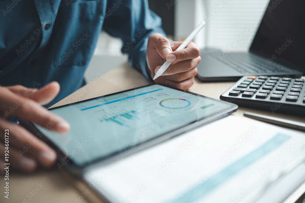 Business professional analyzing financial data on digital tablet ...