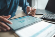 © Garun Studios - Business professional analyzing financial data on digital tablet dashboard with calculator and laptop, representing accounting software, ERP system integration, performance monitoring.