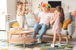 © Pixel-Shot - Little children pranked their father with colorful clown wig at home. April Fool's Day prank