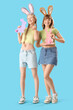© Pixel-Shot - Young girls with Easter bunny ears and paper rabbits on blue background