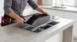 © Irtiko - Handyman installing induction cooktop in modern kitchen