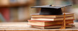 © Atchariya63 - Graduation cap book stack academic success education concept knowledge wooden table library background study scholarship learning motivation