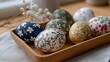 © forenna - Painted Easter eggs with floral patterns and geometric designs displayed on a wooden tray, perfect for Easter holiday craft, festive seasonal decor, traditional celebration, colorful springtime