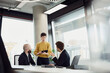 © Westend61 - Colleagues discussing business strategy in a modern office boardroom