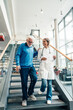© Westend61 - Doctor supporting patient on stairs during hospital consultation