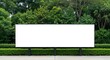 © Tanveer - Large outdoor blank billboard structure stands ready for promotional advertising mockup against a lush green foliage background.