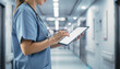 © NurAulia - Medical professional using digital tablet in hospital corridor