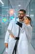 © Rendara Studio - Medical doctors reviewing AI diagnostics brain scan interface in hospital corridor