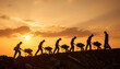 © Bima - Silhouettes of manual laborers pushing wheelbarrows at sunset