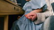 © shine.graphics - Mother and child holding hands under a wooden desk, intimate moment of connection