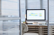 © Seventyfour - Modern office workspace featuring desktop computer displaying digital calendar with colorful schedule blocks, empty chair positioned in front of desk, blinds covering windows