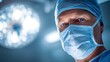 © Oleh - Mature male surgeon in mask and scrub cap looks directly at camera under bright, blurred surgical lights, conveying focused professionalism, expertise and sterile operating room care