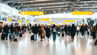 © Bonsales - Busy travelers moving through a crowded modern airport terminal, capturing the dynamic energy of international travel and daily commute