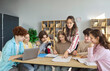 © Studio Romantic - Students and teacher collaborate in classroom teamwork. Teens share ideas over papers and a laptop in a bright library environment. Concept highlights collaborative education and mentorship.