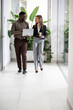 © Zoran Jesic - Diverse business colleagues walking and discussing in office corridor