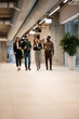 © Zoran Jesic - Diverse business team walking through office hallway during coffee break