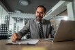 © Migma_Agency - Mature businessman working in office, signing document at desk