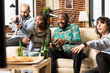 © DC Studio - Excited group of multiethnic friends sitting and playing video games together at home. Bonding over fun, snacks and laughter during casual weekend hangout in modern brick wall apartment.