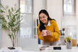 © David - Cheerful young woman uses a laptop at desk in the office with cup of morning coffee.Financial and Accounting concept.