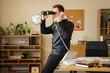© Pixel-Shot - Male detective with binoculars talking by phone in office