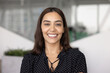 © fizkes - Happy beautiful Middle Eastern businesswoman posing for head shot with toothy smile, looking at camera, laughing, standing for picture in office. Positive young professional, CEO, executive portrait