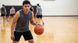 © Николай Срибяник - Hispanic teenage student dribbling basketball in school gym.