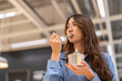 © Art_Photo - Young asian woman eating ice cream cup with wooden spoon in shopping mall, Happy female customer enjoying sweet dessert treat during shopping break, Lifestyle, food court and eco friendly concept