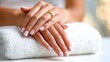 © CreativeArt - Woman's hands with delicate nail polish lying on a white terry towel during a beauty salon or spa session