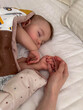 © phpetrunina14 - Peaceful sleeping baby holding adult hand Close Up