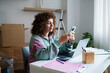 © Westend61 - Woman using smartphone at home workspace with laptop and documents